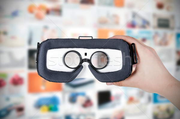 Hand holding virtual reality glasses with streaming in backgroun Stock photo © simpson33
