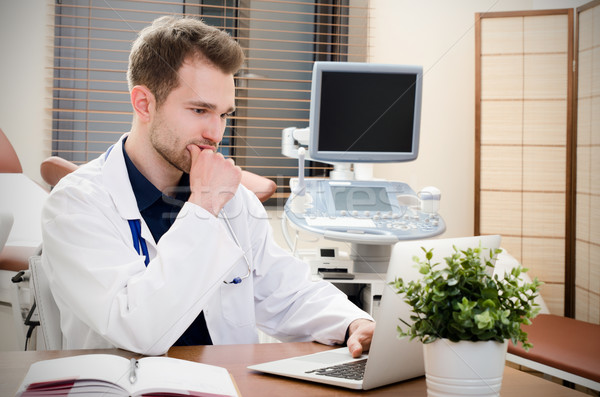 Doctor gynecologist working in office. Ultrasound in background Stock photo © simpson33