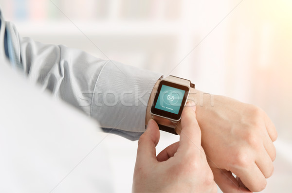 Man using smartwatch with e-mail notifier Stock photo © simpson33