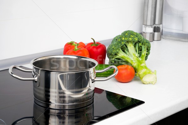 Pot and vegetables in modern kitchen with induction stove Stock photo © simpson33