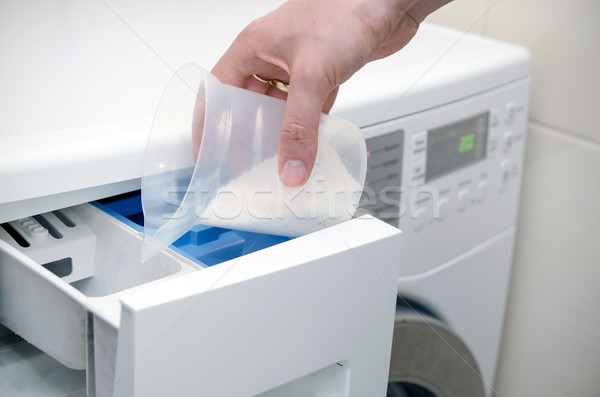 Woman hand pouring washing powder into the washing machine  Stock photo © simpson33