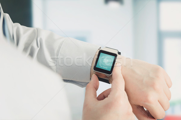 Man using smartwatch with e-mail notifier Stock photo © simpson33