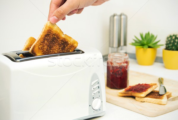 Breakfast prepare. Toaster and toast with jam in modern kitchen Stock photo © simpson33