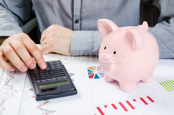Man calculates money. Piggy bank and business documents on desk Stock photo © simpson33