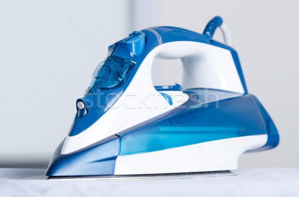 Modern blue steam iron on ironing board Stock photo © simpson33