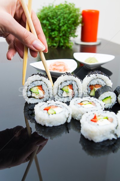 Hand holding stick with maki sushi set Stock photo © simpson33