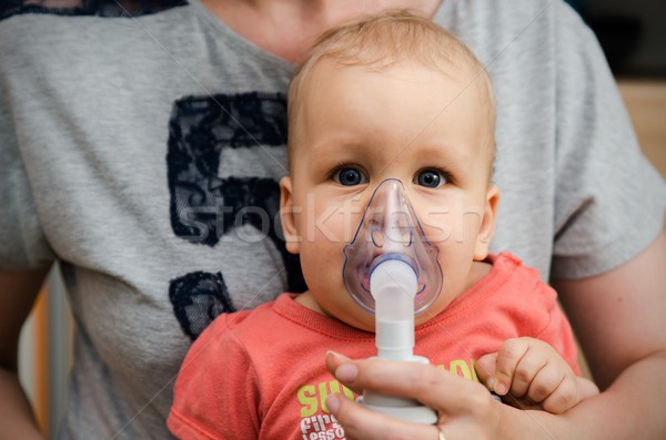 Child making inhalation with mask on his face.  Stock photo © simpson33