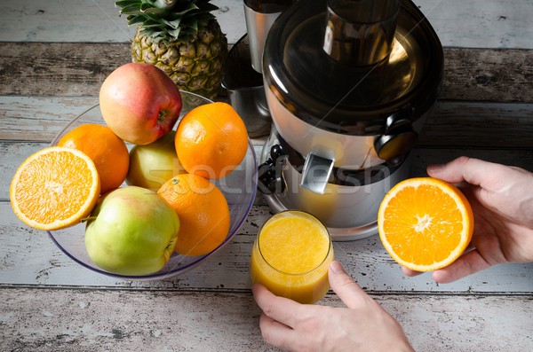 Man preparing fresh orange juice. Fruits in background Stock photo © simpson33