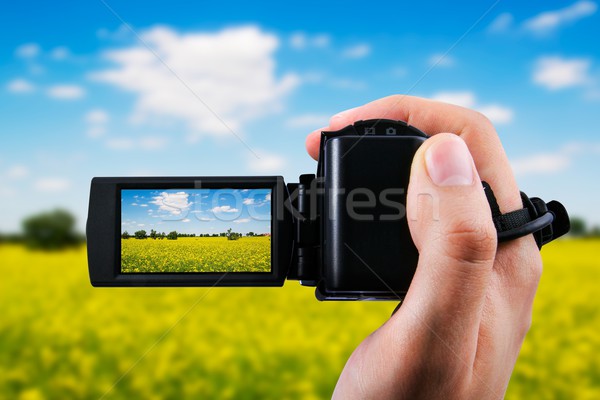 Video camera or camcorder recording yellow field and blue sky Stock photo © simpson33
