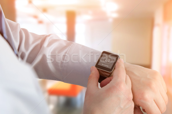 Man using smartwatch with e-mail notifier Stock photo © simpson33