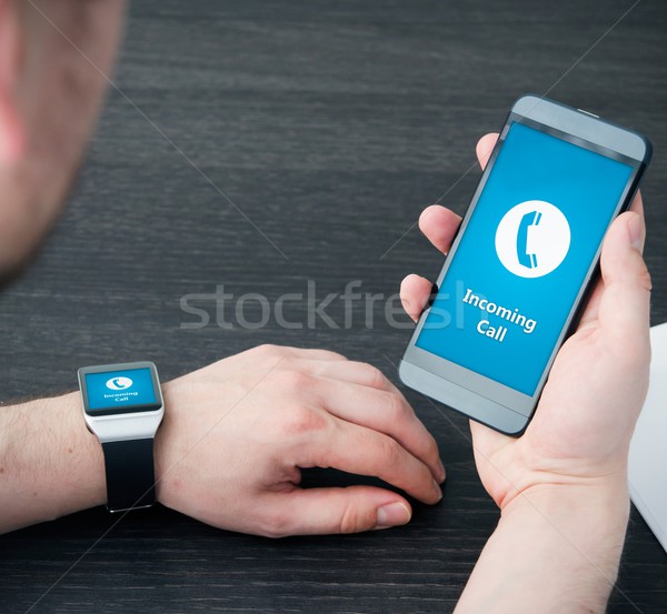 Incoming call notification on smart watch connected to smart pho Stock photo © simpson33