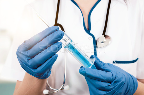 Woman doctor with gloves holding medical injection syringe and s Stock photo © simpson33