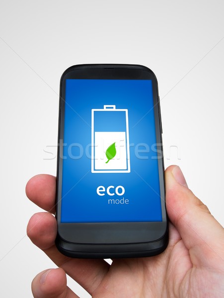 Man holding phone with eco battery mode on display Stock photo © simpson33