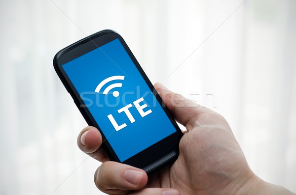 Hand holding mobile phone with LTE fast internet technology Stock photo © simpson33