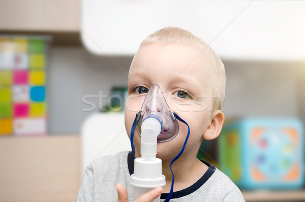 Child making inhalation with mask on his face.  Stock photo © simpson33