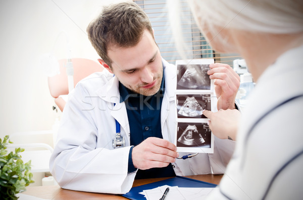 Doctor showing baby ultrasound image to pregnant woman Stock photo © simpson33