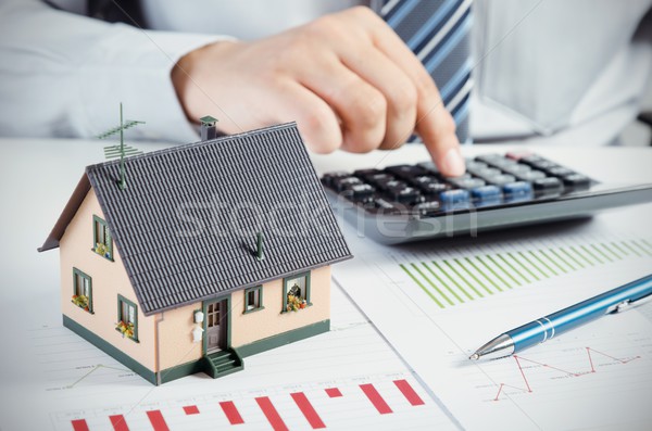 Stock photo: Businessman calculate the cost of building and maintaining home