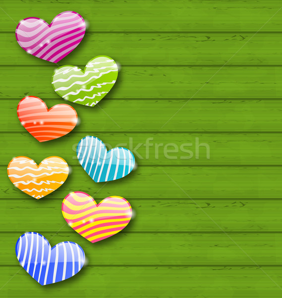 Multicolored striped hearts on green wooden texture for Valentin Stock photo © smeagorl