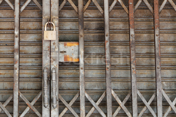 Dirty padlock on rusty steel shutter door Stock photo © smuay