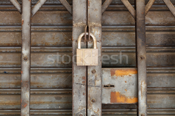 Dirty padlock on rusty steel shutter door Stock photo © smuay