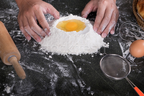 Stock photo: Woman's hands knead dough with flour, eggs and ingredients. at k