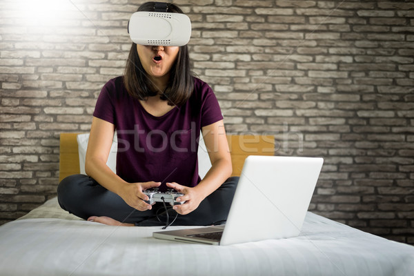 Happy smiling young woman playing game while getting experience  Stock photo © snowing