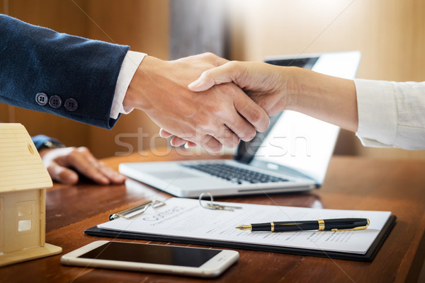 Stock photo: House developers agent or financial advisor and customers shakin