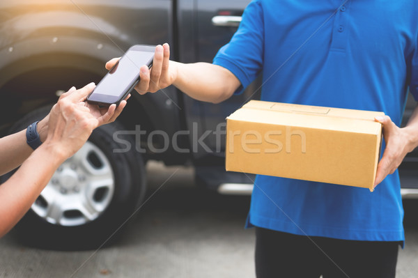 messenger man hold box and talk on smart phone and payment termi Stock photo © snowing