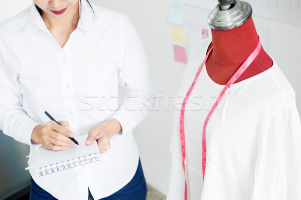 Asian tailor adjusts garment design on mannequin in workshop mak Stock photo © snowing