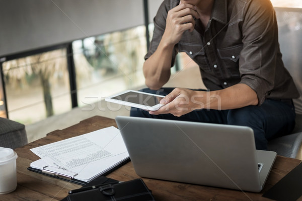 Modern businessman with tablet computer reading news and work re Stock photo © snowing