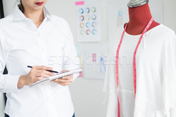 Asian tailor adjusts garment design on mannequin in workshop mak Stock photo © snowing