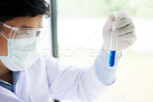 Asian scientific researcher working in laboratory holds test tub Stock photo © snowing