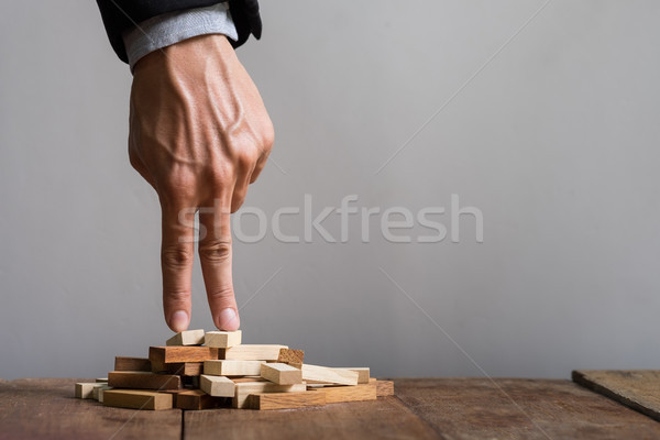 Hand liken business person stepping up a toy wooden block to goa Stock photo © snowing