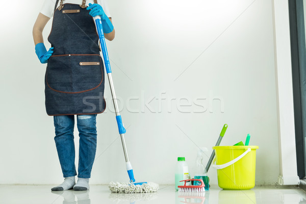 Stock photo: Young housekeeper cleaning floor mobbing holding mop and plastic