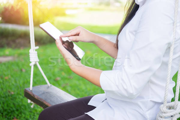 women uses tablet for working while lying on a sunbed in garden. Stock photo © snowing