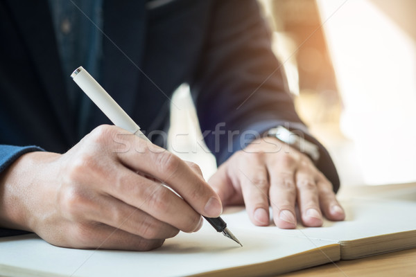 Businessman writing in a document. Focus on the tip of the pen Stock photo © snowing