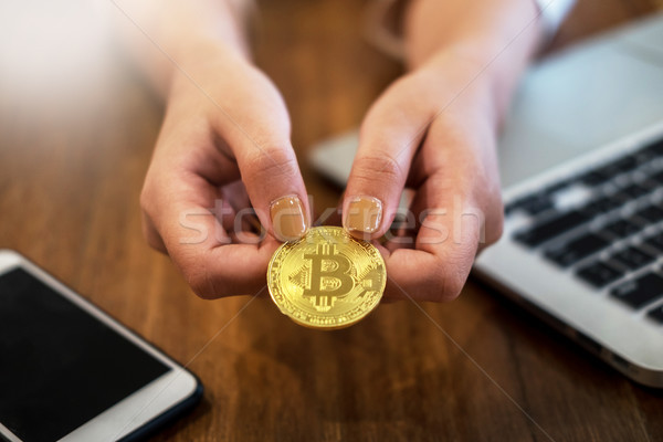 Stock photo: hand with golden metal Bitcoin crypto currency investment- symbo