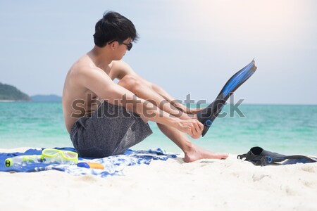 Attractive young man on the beach applying sunscreen to his body Stock photo © snowing