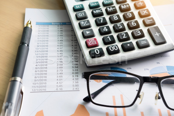 financial charts on the table with laptop, calculator, pen and g Stock photo © snowing