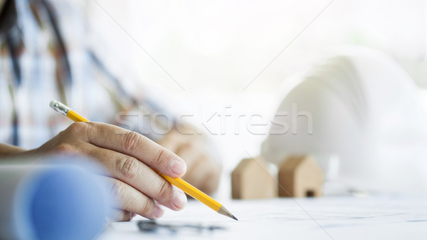 Close-up Of Person's Hand Drawing Plan On Blue Print with archit Stock photo © snowing