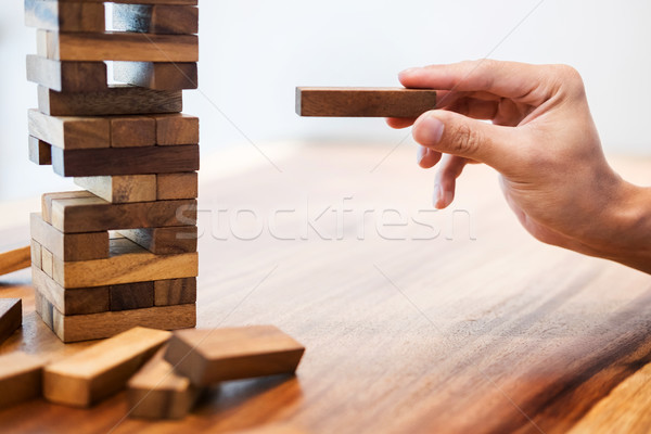 Business man placing wooden block on a tower concept of risk con Stock photo © snowing