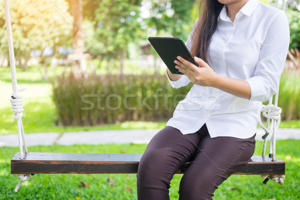 women uses tablet for working while lying on a sunbed in garden. Stock photo © snowing