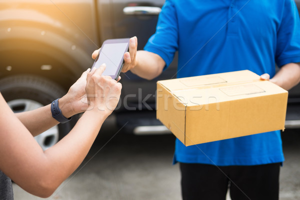 messenger man hold box and talk on smart phone and payment termi Stock photo © snowing