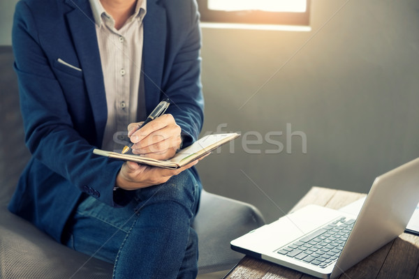Thoughtful young business man in casual shirt holding note pad   Stock photo © snowing