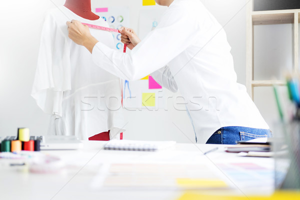 Asian tailor adjusts garment design on mannequin in workshop mak Stock photo © snowing