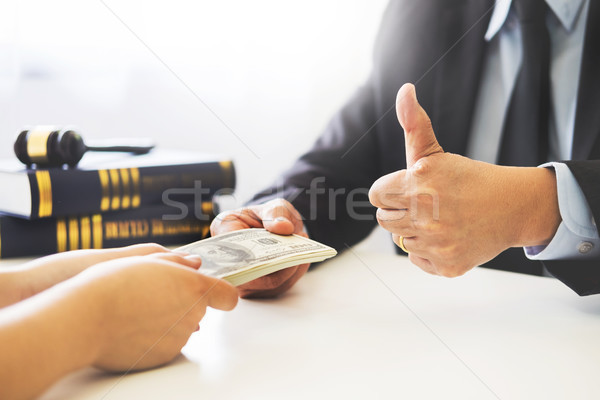Lawyer being offered receiving money as bribe from client at des Stock photo © snowing
