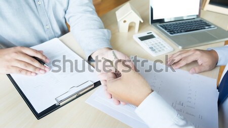 Estate agent in suit sitting in an office desk Handing over of h Stock photo © snowing