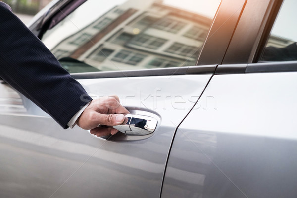 Chauffeur s hand on handle. Close-up of man in formal wear openi Stock photo © snowing