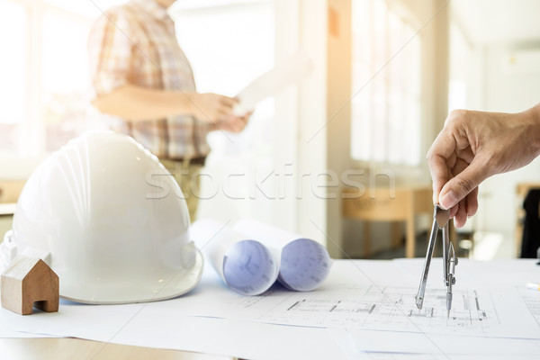 Close-up Of Person's Hand Drawing Plan On Blue Print with archit Stock photo © snowing