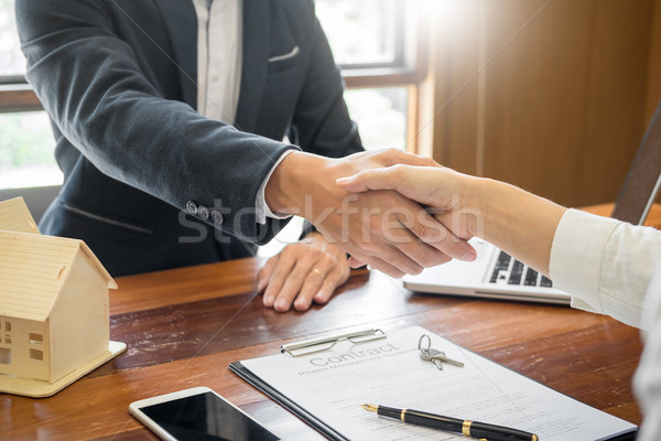 Stock photo: House developers agent or financial advisor and customers shakin